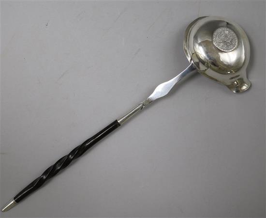 An 18ct century silver toddy ladle with baleen handle and bowl with inset coin, 31.7cm.